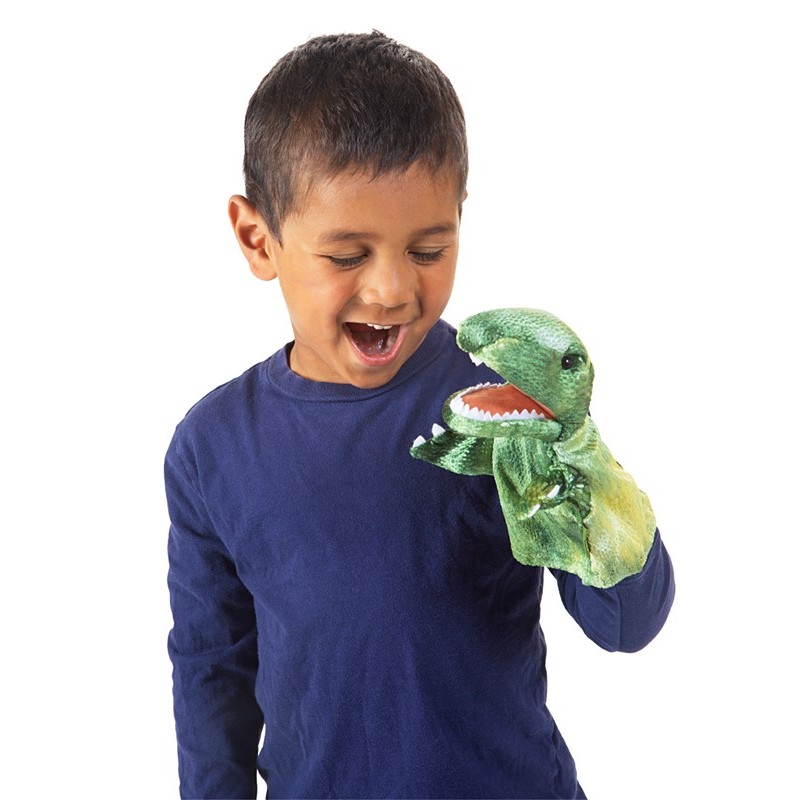 Laughing boy wearing a green Folkmanis Little T-Rex hand puppet with an open mouth and white teeth on his hand