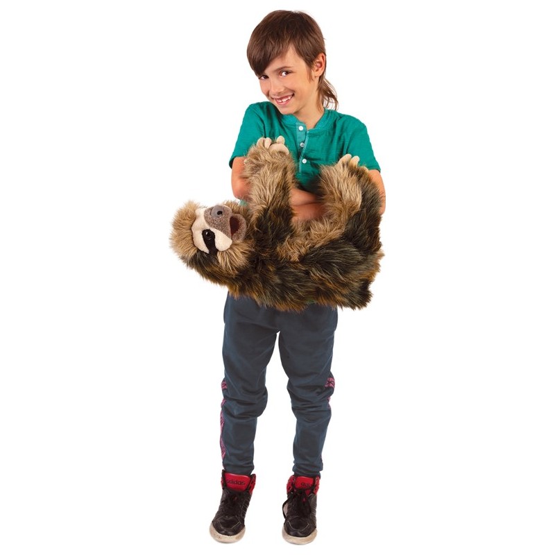 Laughing boy holding the Folkmanis three-toed sloth hand puppet with both arms, brown mottled fur, open mouth