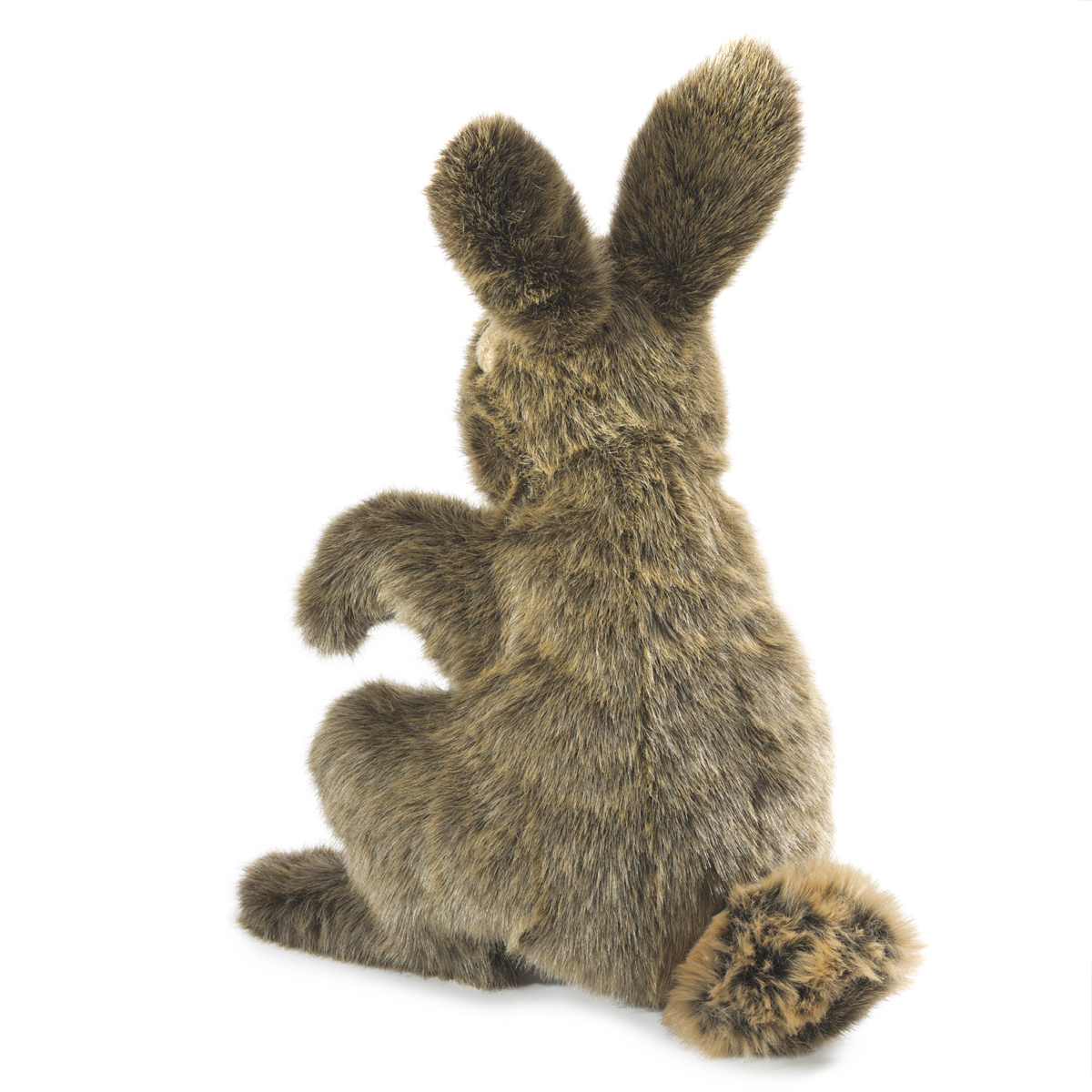 Folkmanis hand puppet hare in brown-grey long-pile plush, seated from behind with upright ears and fluffy tail