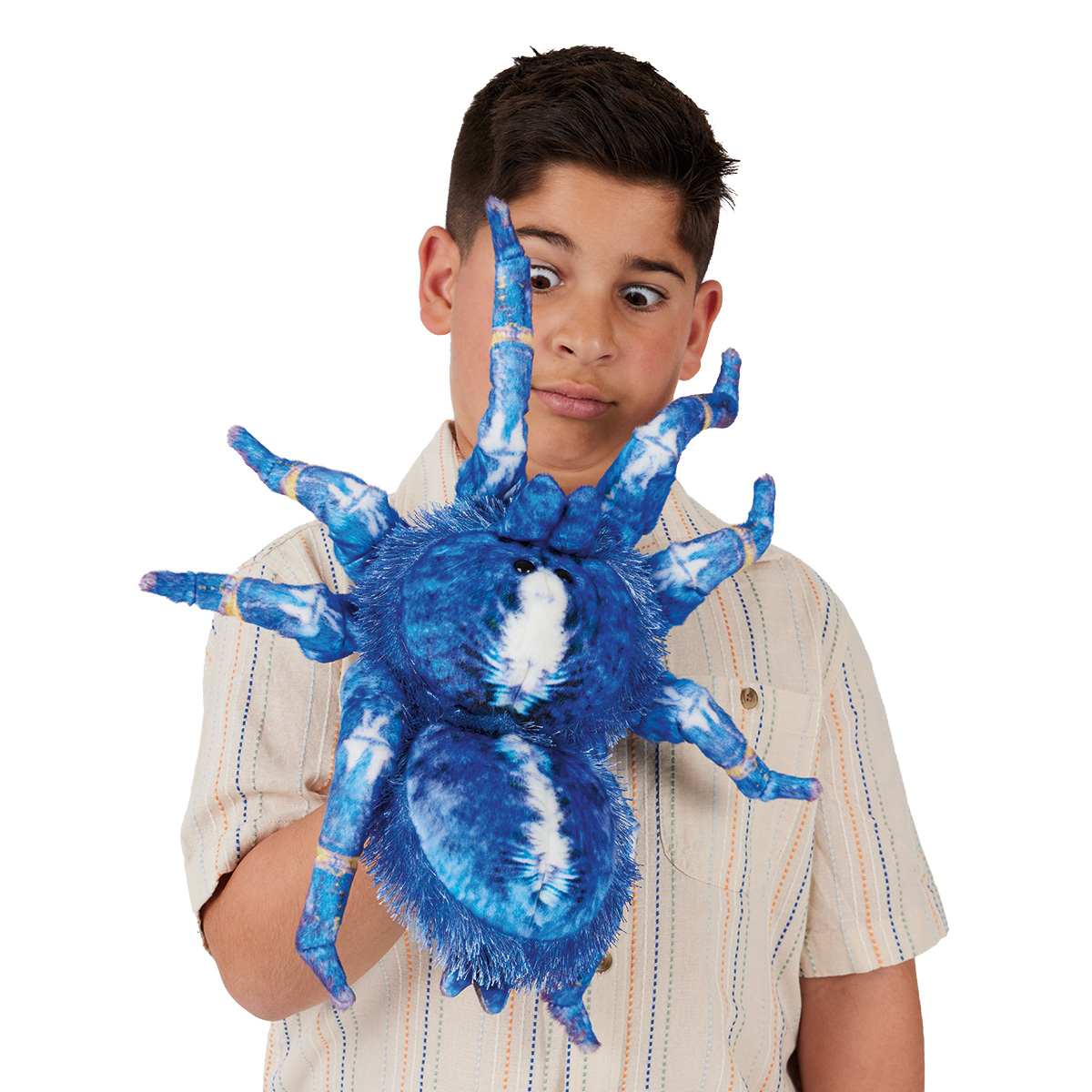 Boy using the Folkmanis blue ornamental tarantula hand puppet with a blue-and-white plush body and eight legs on his hand