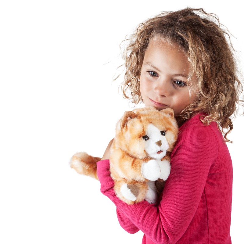 Girl in pink top cuddling the ginger and white Folkmanis Orange Tabby Kitten hand puppet
