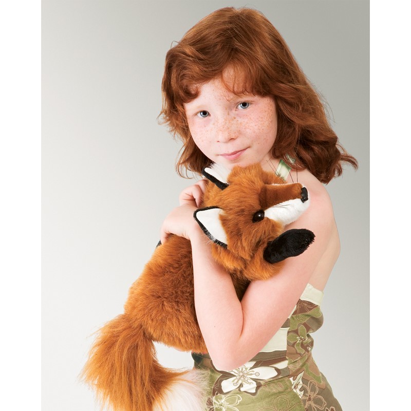 Girl holding the Folkmanis small red fox hand puppet with reddish-brown fur, white chest and black paws in her arms