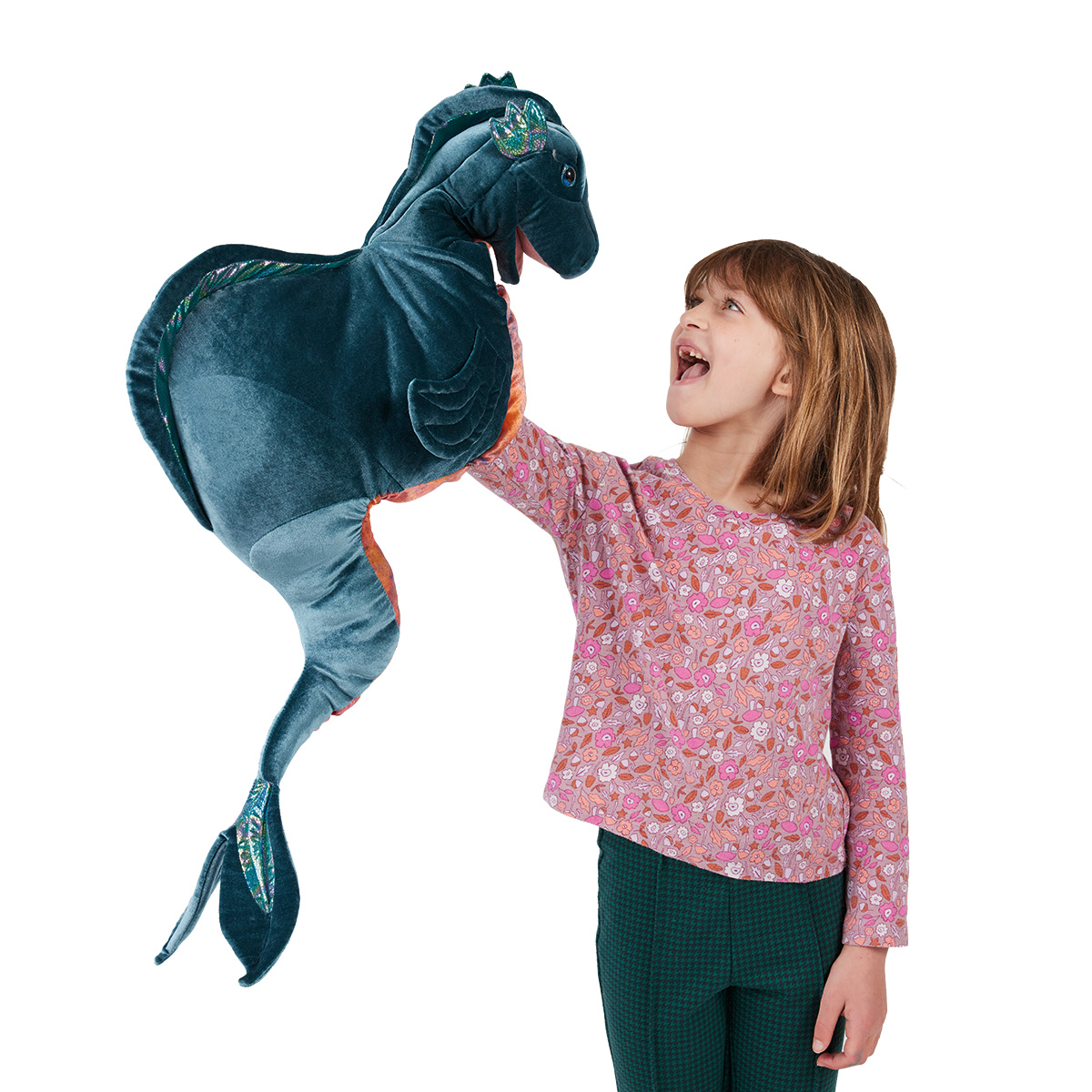 Girl operating a large Folkmanis Loch Ness Monster hand puppet in teal with glittery fins, laughing with delight