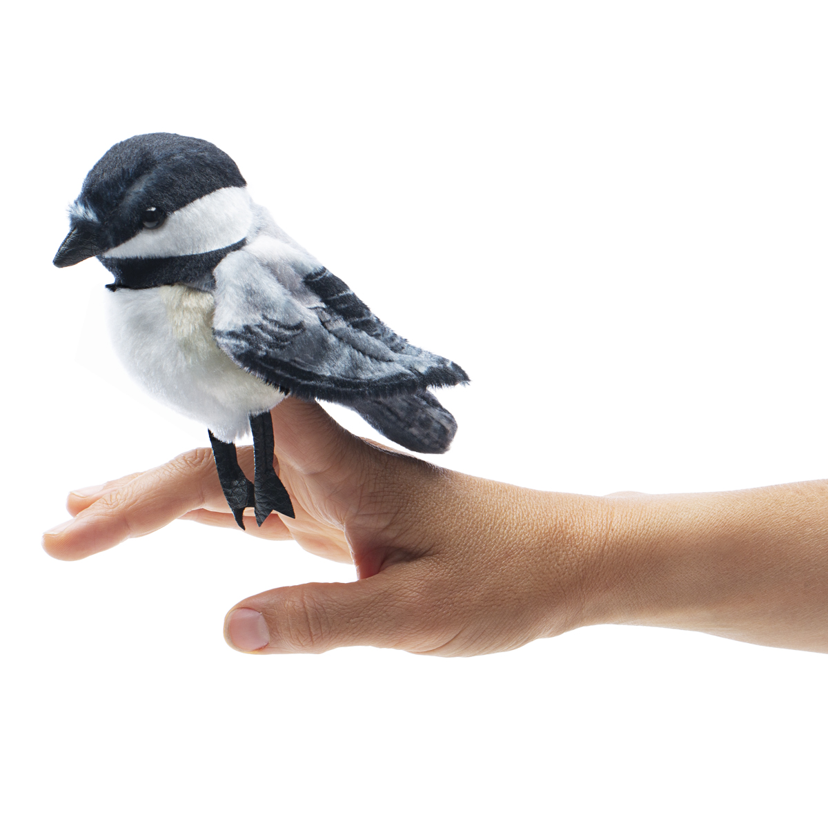 Folkmanis mini chickadee finger puppet with black cap and white chest, perched on a finger, side view