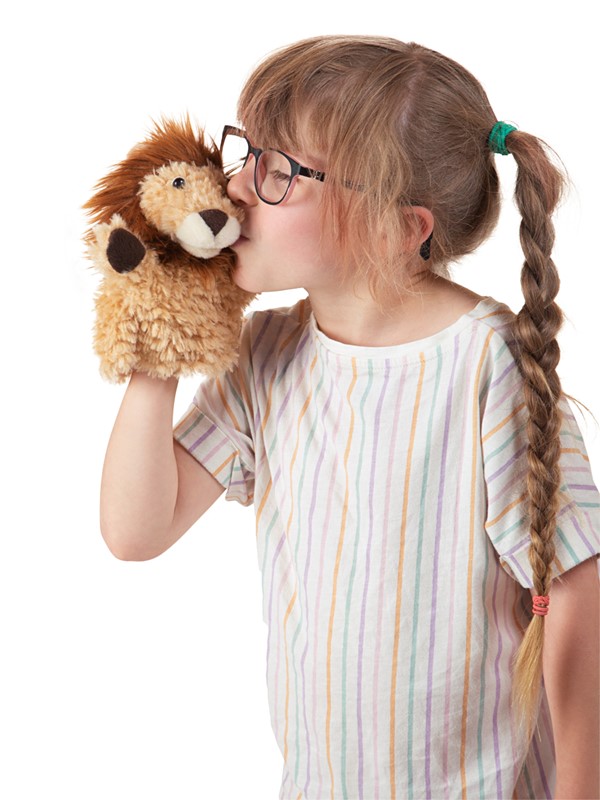 Girl with braids kissing a Folkmanis little lion hand puppet with light brown plush fur and a dark mane