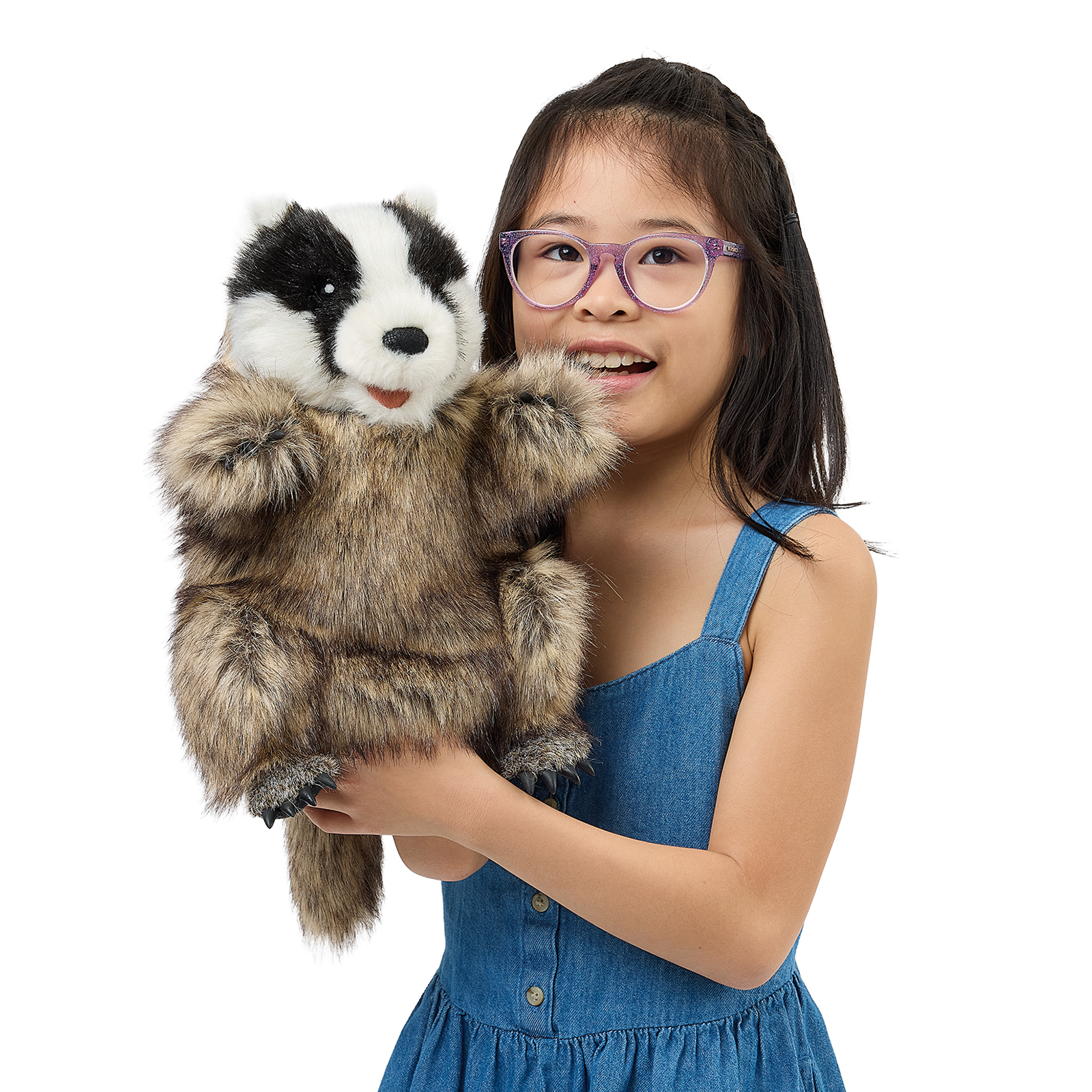 Folkmanis badger hand puppet worn on a girl's arm, a close view of the striped head with its mouth open.