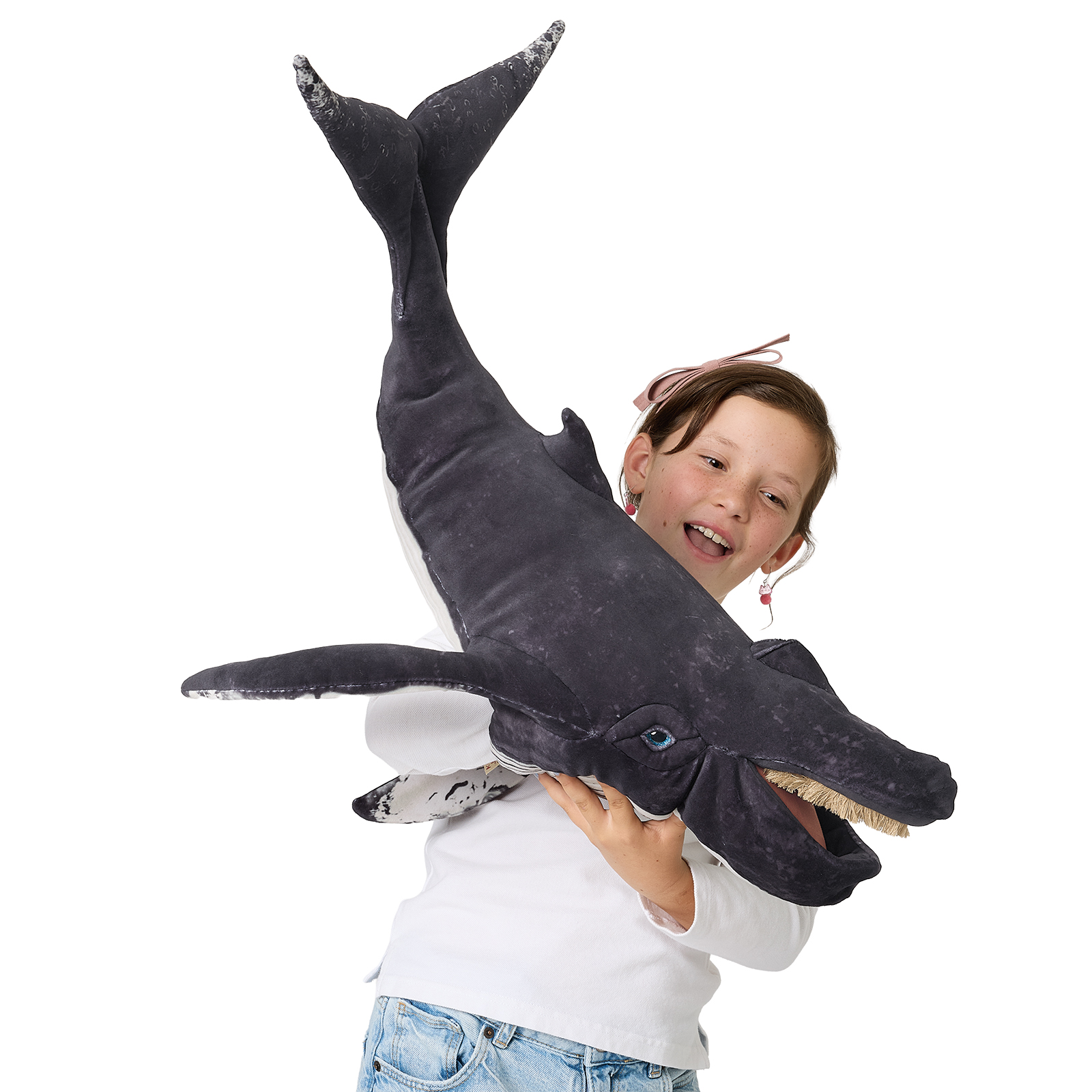 Folkmanis hand puppet humpback whale in dark grey with white belly patches, child holding the large plush figure with open mouth toward the camera