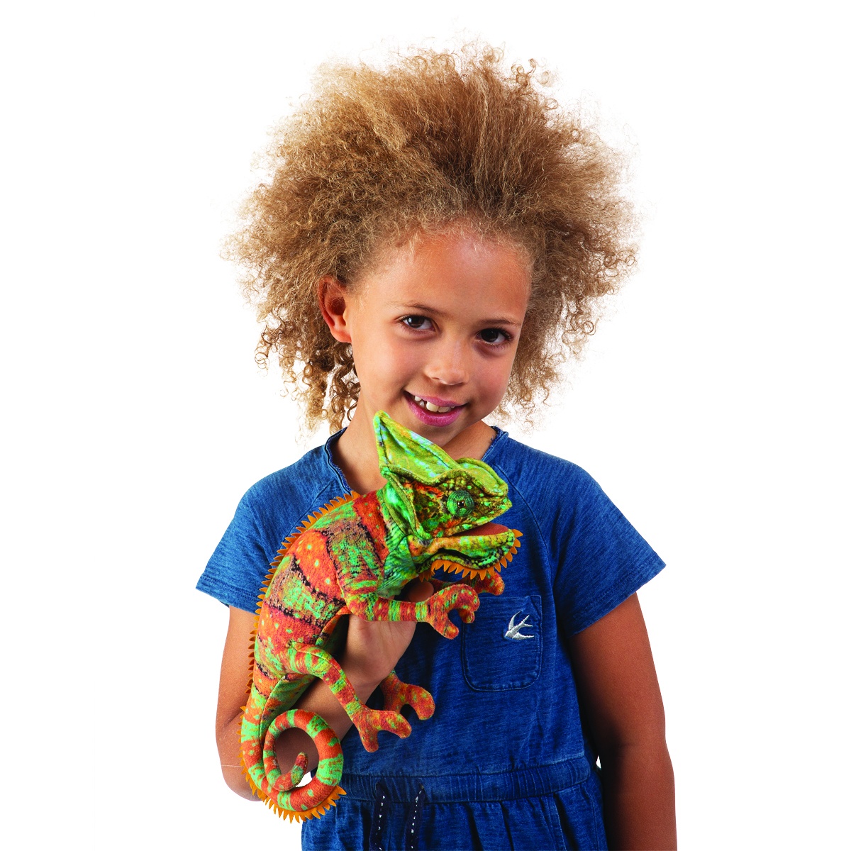Girl holding the Folkmanis small chameleon hand puppet in green and orange with a textured scale pattern, facing sideways toward the camera