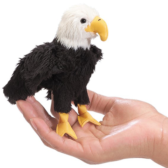 Folkmanis mini finger puppet bald eagle with black plumage and yellow beak sitting on an open palm