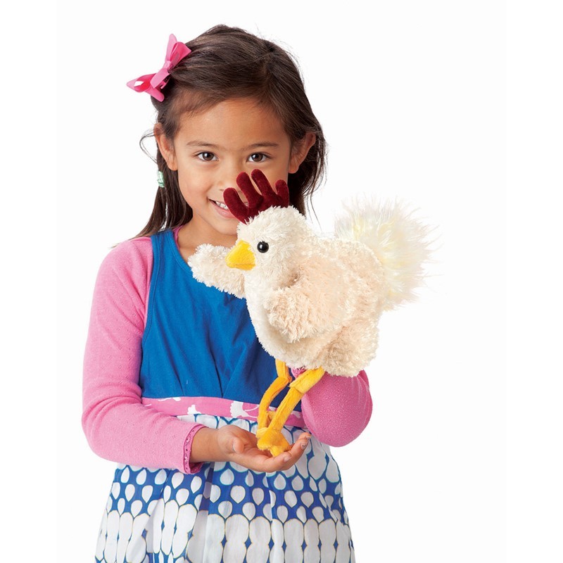 Girl operating the Folkmanis Funky Chicken hand puppet with cream plush, red comb, and yellow legs