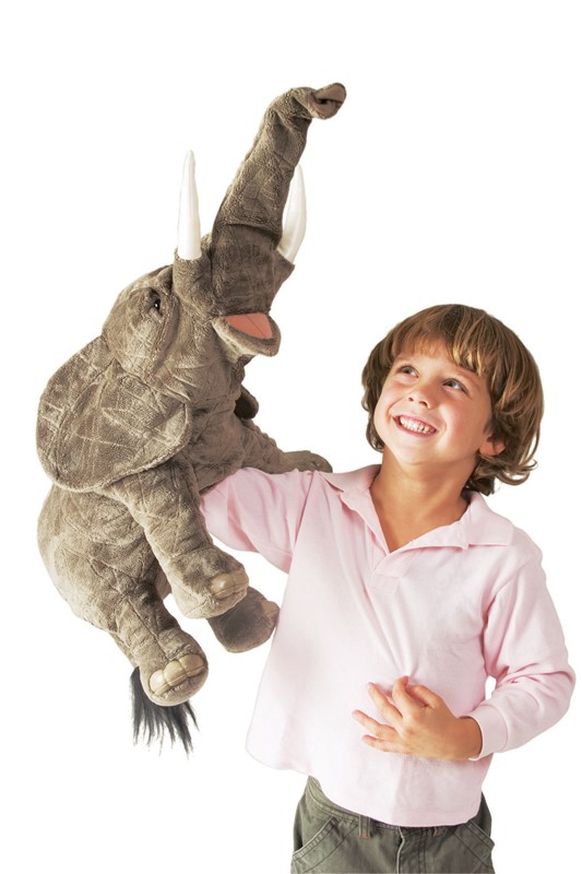 Laughing boy holding a Folkmanis elephant hand puppet with raised trunk up in the air