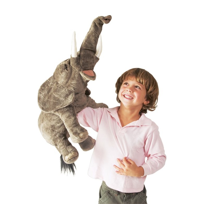 Laughing boy holding a Folkmanis elephant hand puppet with raised trunk up in the air