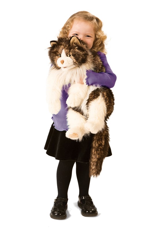 Small girl holding a large Folkmanis hand puppet fluffy cat with brown and white fur in her arms