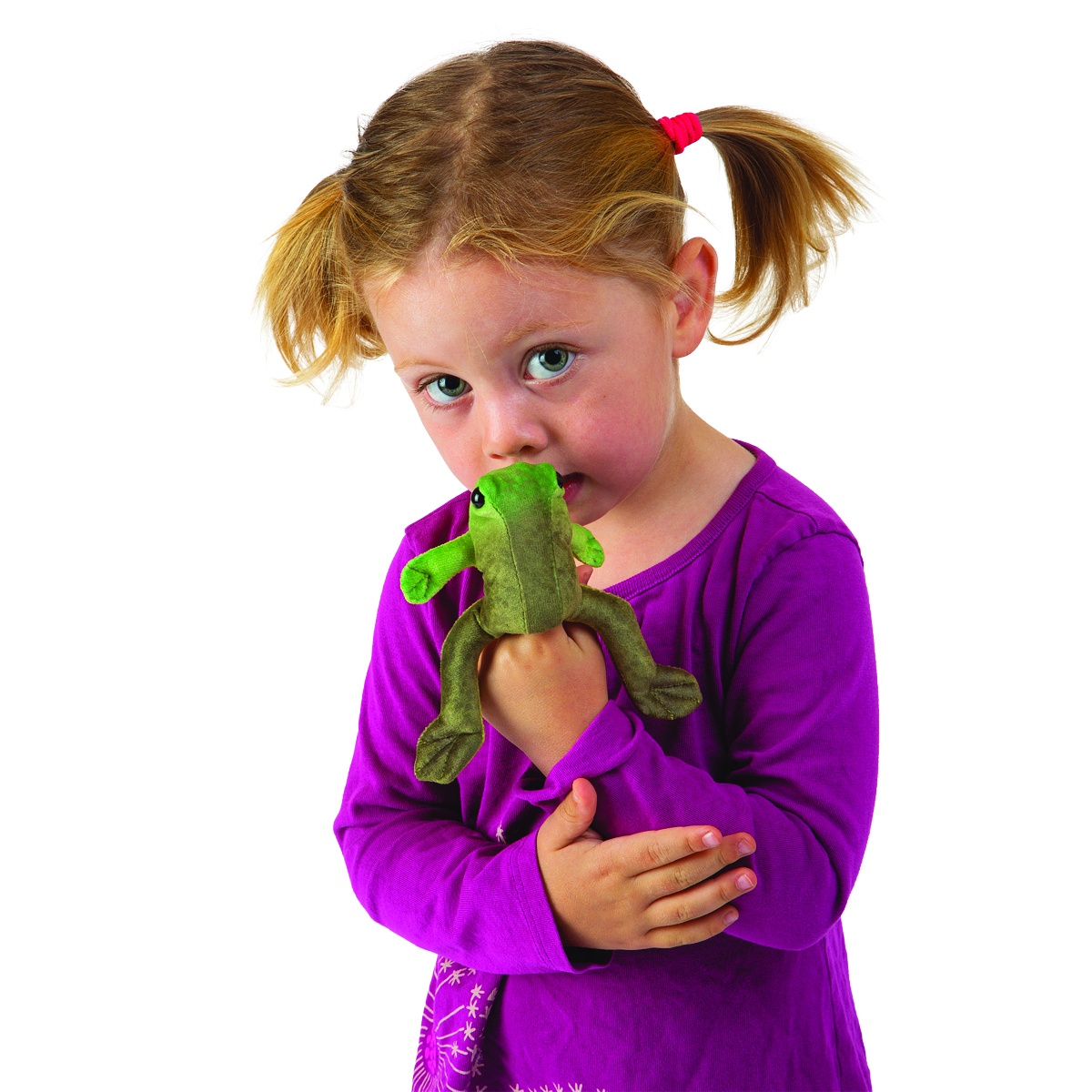 Young girl with pigtails wearing a green Folkmanis Mini Sitting Frog finger puppet, looking at it curiously