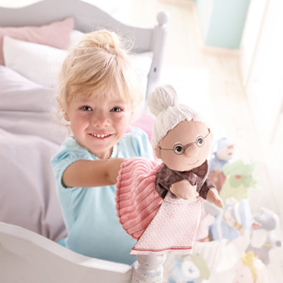 HABA baby hand puppet grandma, lifestyle photo of a girl in bed