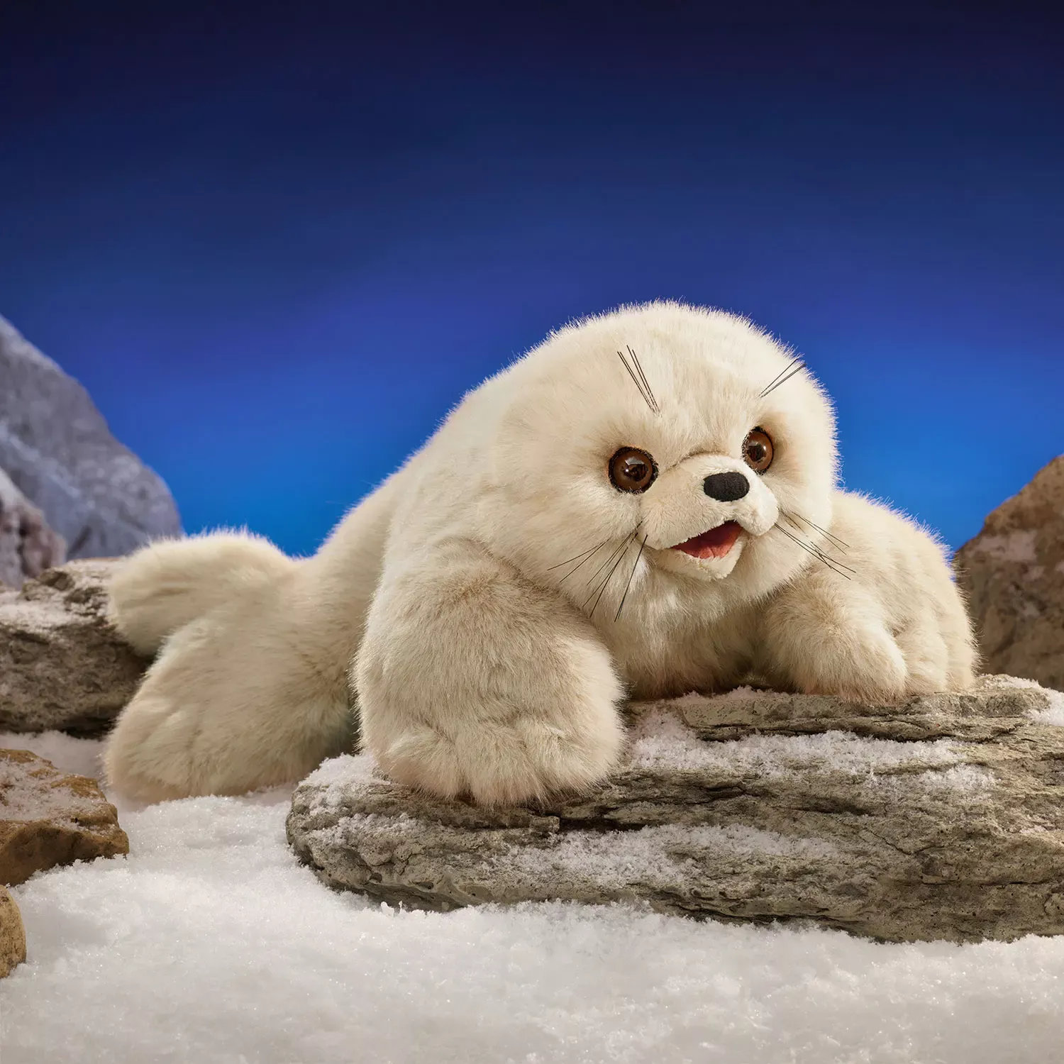 Folkmanis hand puppet baby harp seal with cream plush fur, open mouth and whiskers, posed on snow-covered rocks
