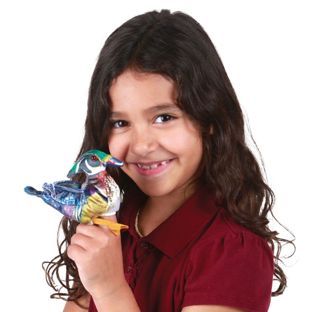 Girl holding a small Folkmanis wood duck finger puppet with a green head and colourful plumage in her hand