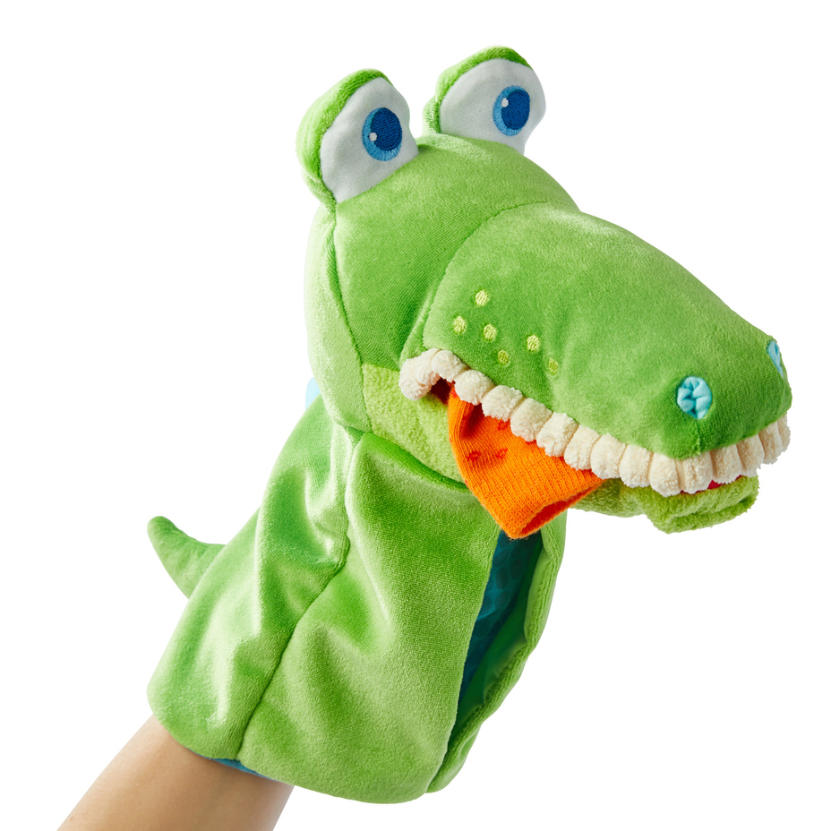 HABA baby hand puppet crocodile Allesfresser, worn on an arm with an orange fabric piece in its mouth