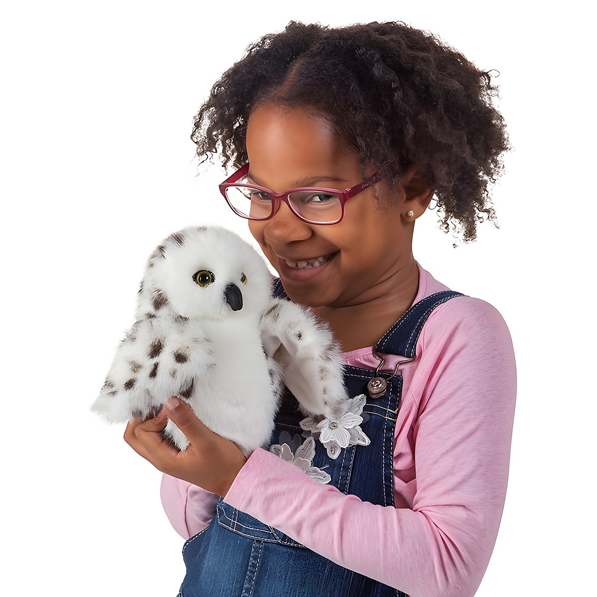 Girl holding the Folkmanis little snowy owl hand puppet with white plumage and dark spots in her hands