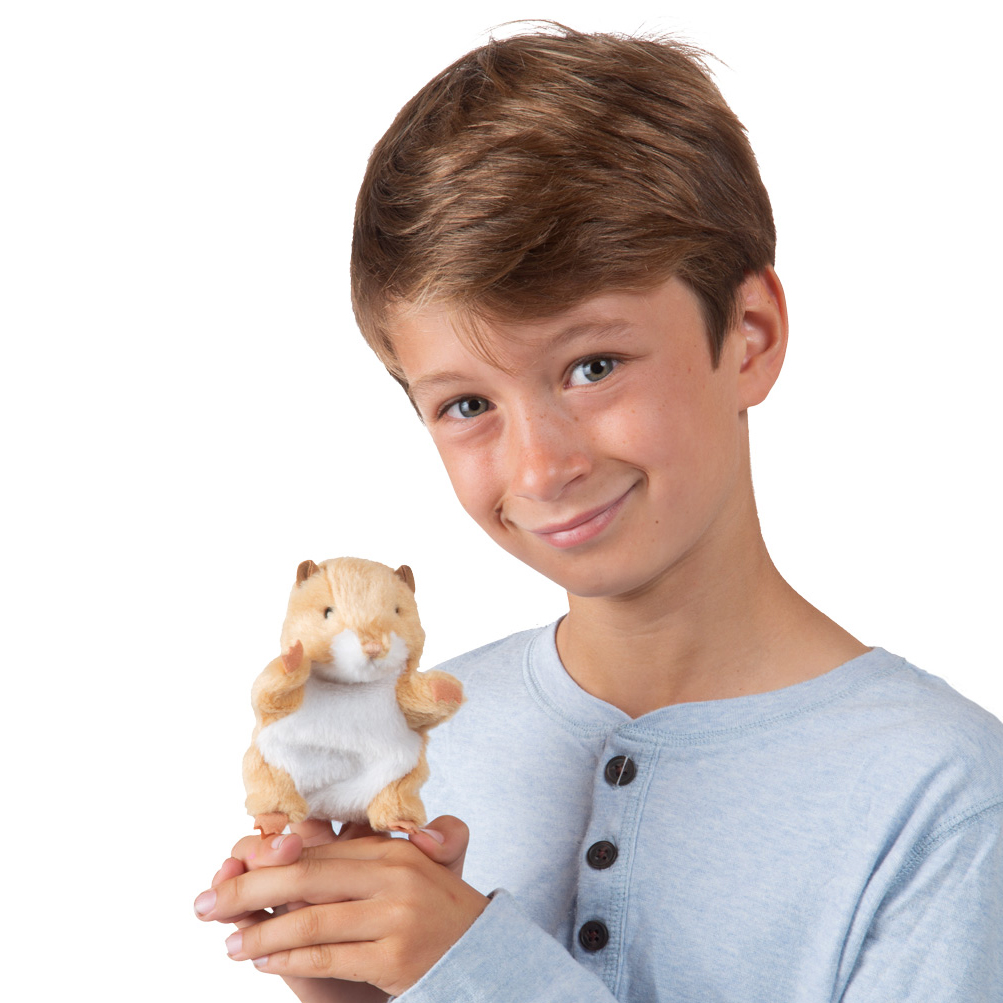 Boy holding a small Folkmanis mini hamster finger puppet in beige and white upright in both hands