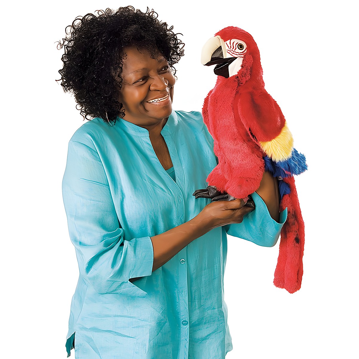 Folkmanis scarlet macaw hand puppet in vibrant red with yellow-blue wings, held on the arm of a smiling woman