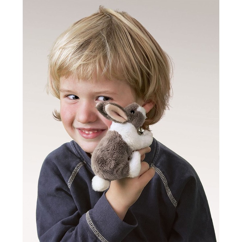 Smiling boy holding a small brown and white Folkmanis mini rabbit finger puppet on his finger