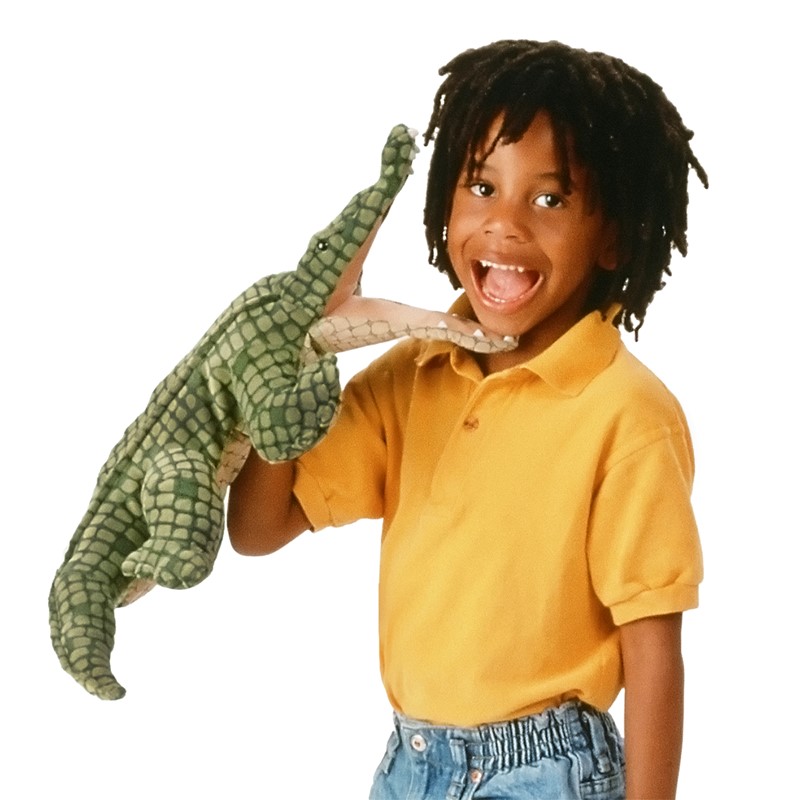 Child wearing a green Folkmanis alligator hand puppet with textured scale detailing over their arm, mouth open