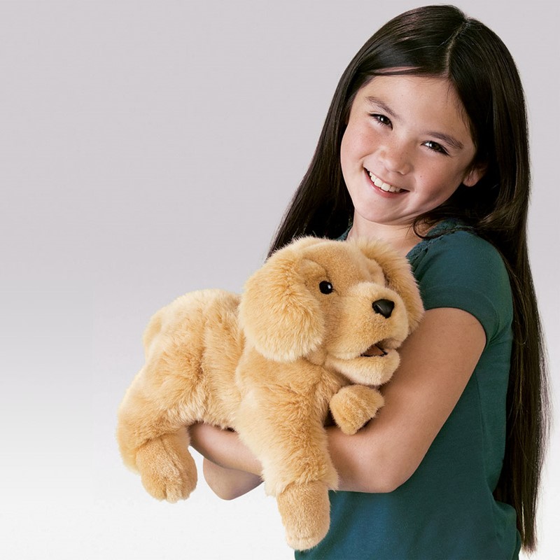 Girl holding a Folkmanis Golden Retriever puppy hand puppet with movable mouth in golden plush in her arms