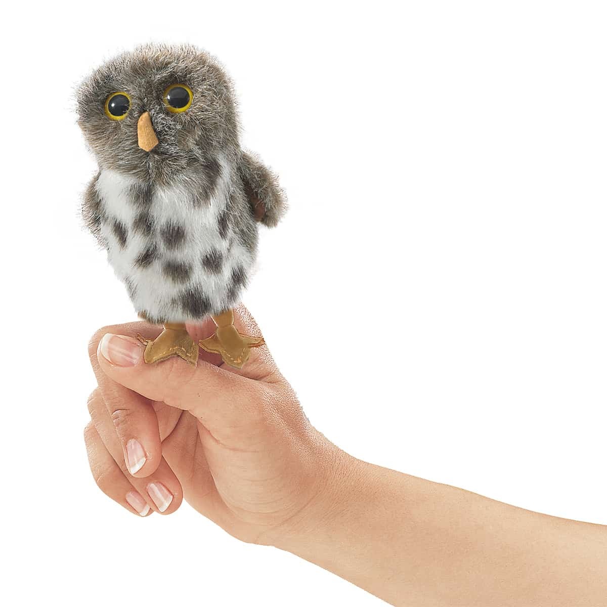 Folkmanis mini spotted owl finger puppet on an index finger, grey-white plumage with dark spots and yellow eyes