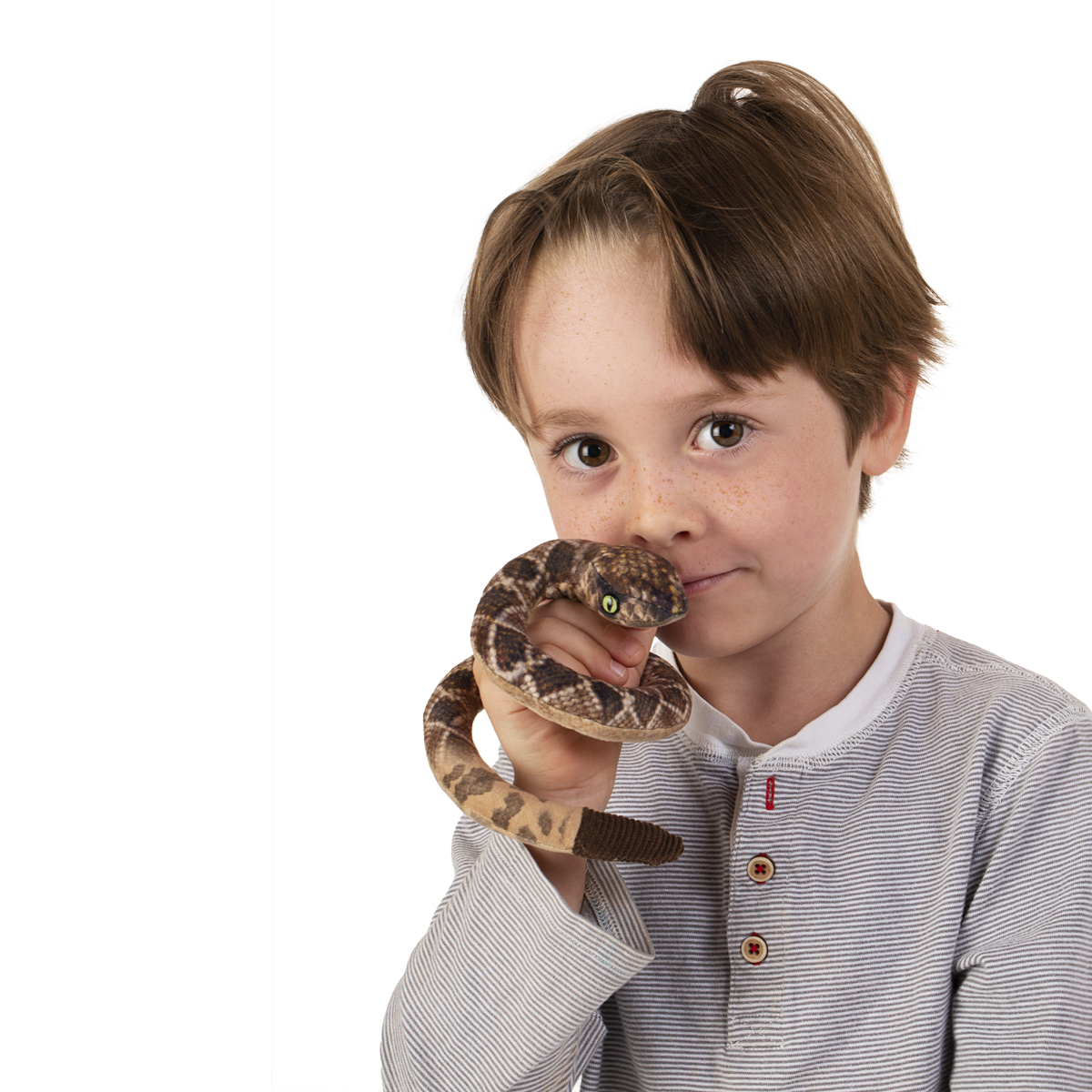 Boy holding a Folkmanis mini rattlesnake finger puppet with a brown and beige scale pattern, with the head held close to his face