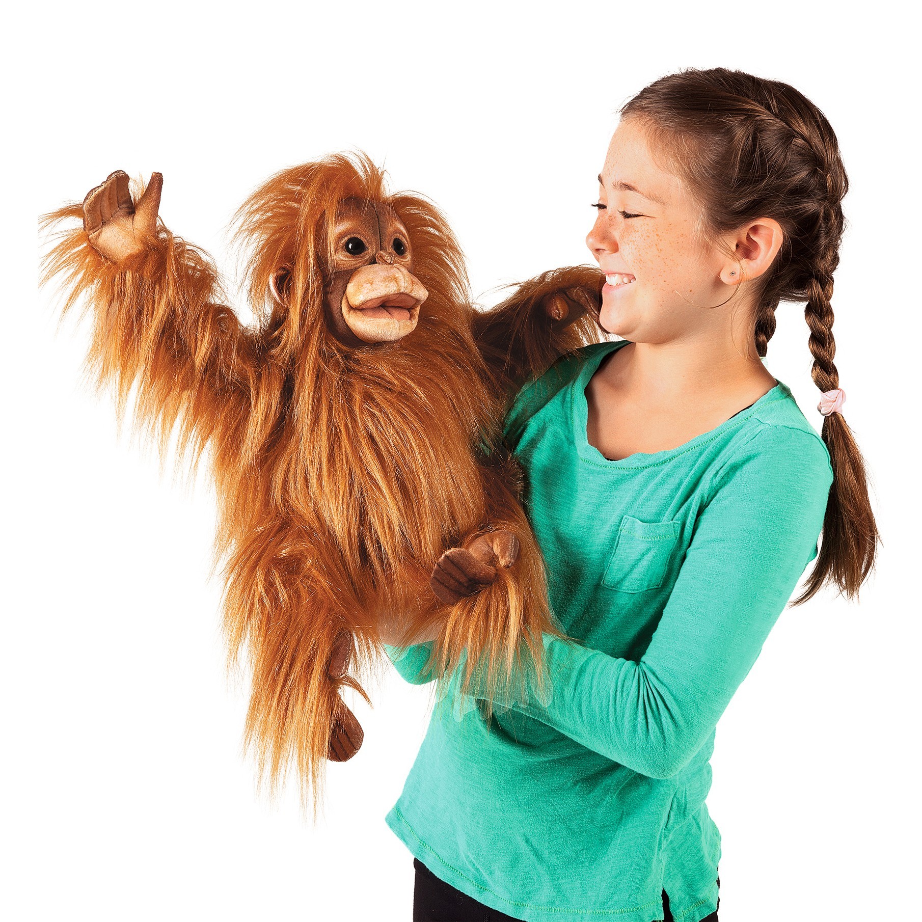Girl operating the Folkmanis baby orangutan hand puppet with a movable mouth and long reddish-brown plush fur, side view