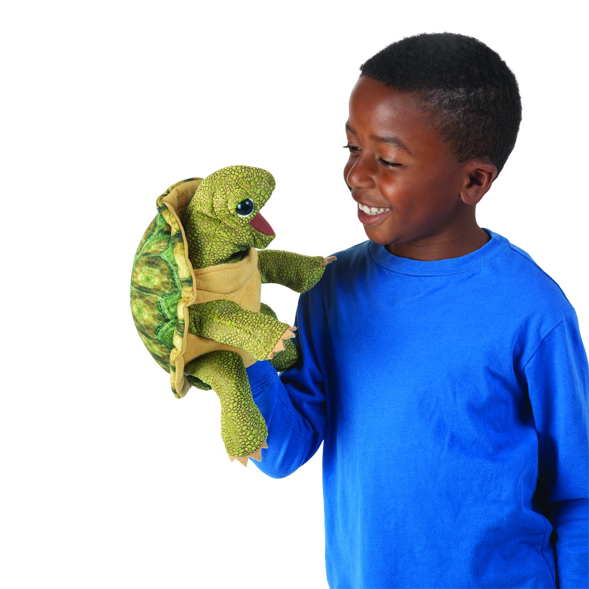 Boy wearing a blue top holds a Folkmanis standing tortoise hand puppet with a green patterned shell and movable mouth on his hand
